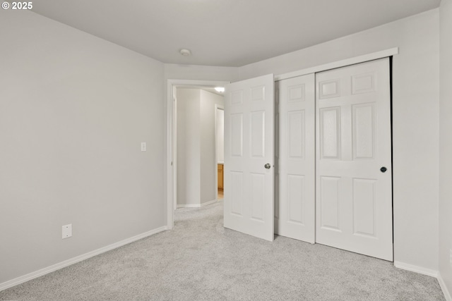 unfurnished bedroom featuring light colored carpet and a closet