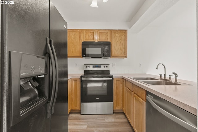 kitchen featuring light hardwood / wood-style floors, sink, and black appliances