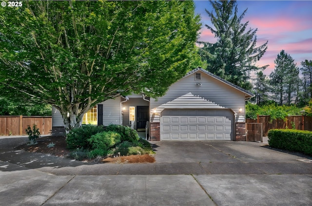 1041 Irving Rd, Eugene, OR 97404 - view of property hidden behind natural elements with concrete driveway, brick siding, and an attached garage
