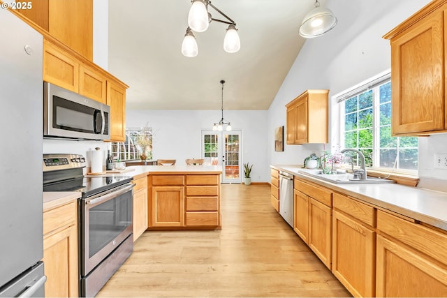 1041 Irving Rd, Eugene, OR 97404 - kitchen featuring stainless steel appliances, a peninsula, light wood-type flooring, lofted ceiling, and light countertops