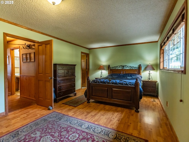 10160 NW Gordon Rd, Cornelius, OR 97113 - bedroom featuring light wood finished floors, a textured ceiling, and ornamental molding