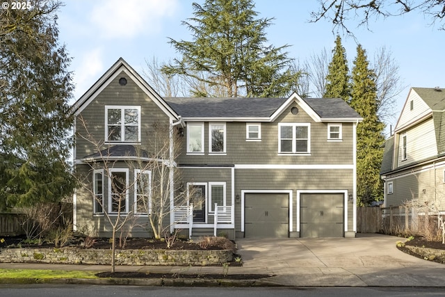 view of front facade with a garage, concrete driveway, and fence