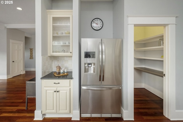 kitchen with dark countertops, dark wood-style floors, glass insert cabinets, and stainless steel refrigerator with ice dispenser