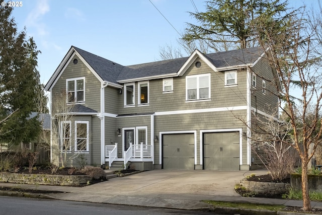 view of front facade featuring driveway, a shingled roof, and a garage