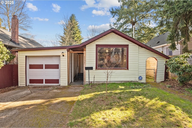 view of front of home with a garage, driveway, a front lawn, and fence