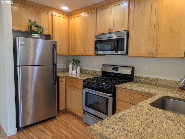 3159 SW Jaden Dr, Beaverton, OR 97003 - kitchen featuring stainless steel appliances, light wood-type flooring, a sink, light stone counters, and light brown cabinets