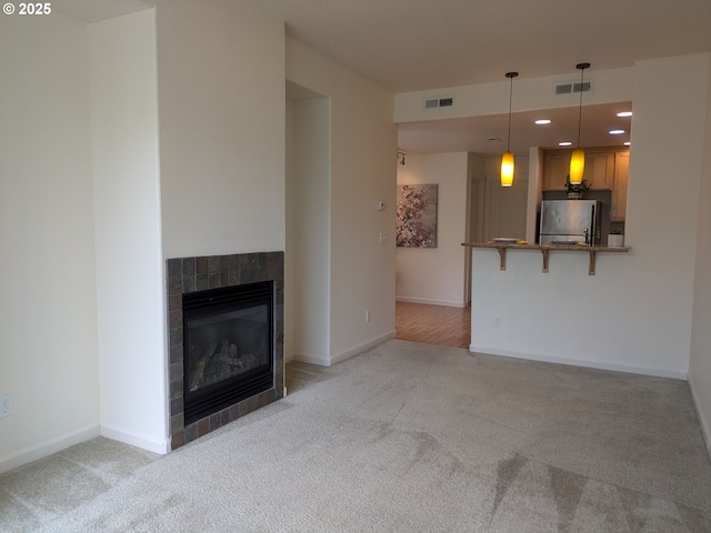 3159 SW Jaden Dr, Beaverton, OR 97003 - unfurnished living room with light colored carpet, a fireplace, recessed lighting, and baseboards