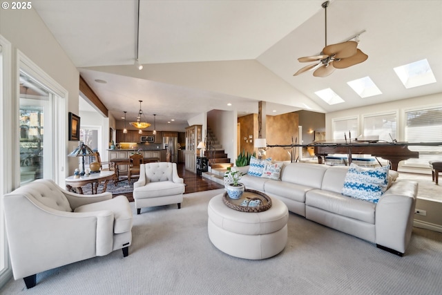 carpeted living room featuring stairs, ceiling fan, and vaulted ceiling