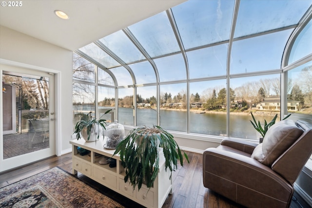 sunroom / solarium featuring plenty of natural light and a water view