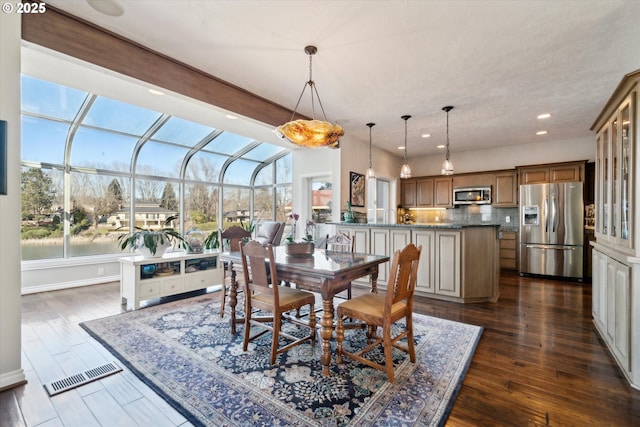 dining area featuring a sunroom, visible vents, dark wood finished floors, and recessed lighting