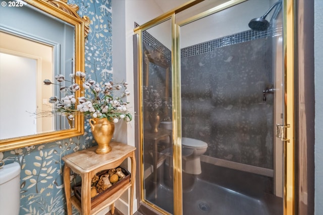 bathroom with a shower stall, toilet, and wallpapered walls