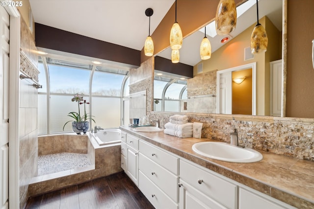 full bathroom with a garden tub, a sink, decorative backsplash, and wood finished floors