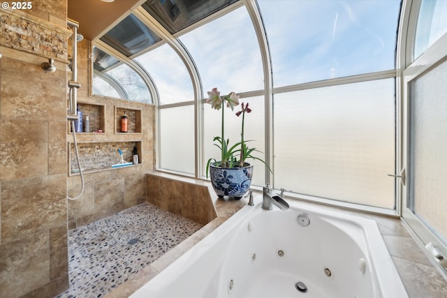 full bathroom with a jetted tub and tiled shower