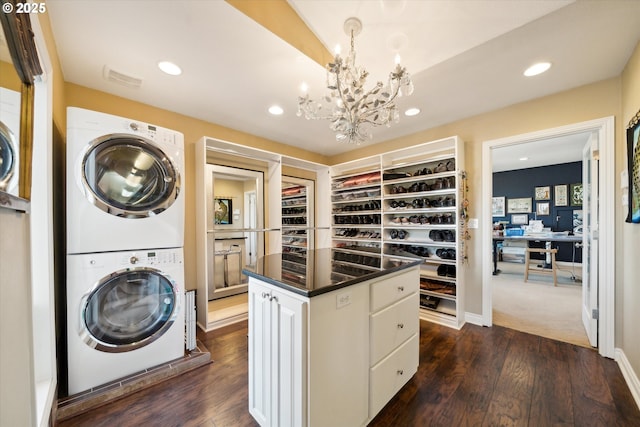 interior space with stacked washer / dryer, dark wood-style flooring, and visible vents