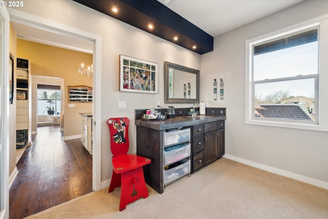 interior space featuring light wood-type flooring, a sink, and baseboards