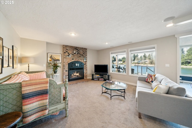 carpeted living room with a glass covered fireplace, a textured ceiling, and baseboards