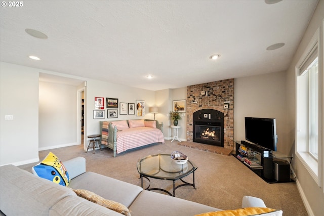 bedroom with carpet, recessed lighting, a glass covered fireplace, a textured ceiling, and baseboards