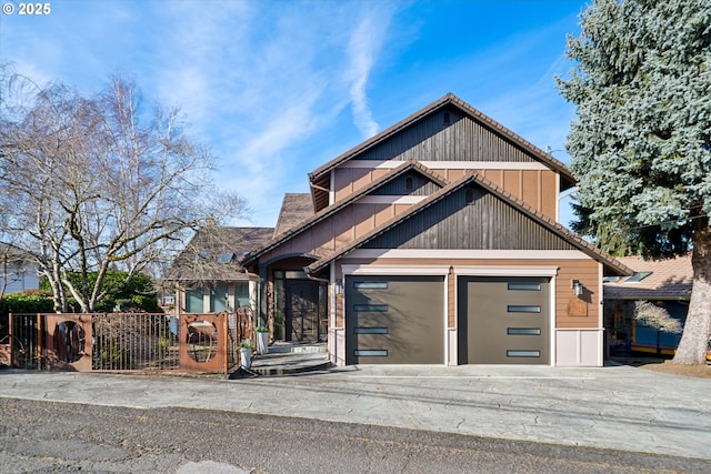 view of front facade featuring a garage, driveway, and a fenced front yard