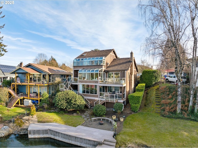 back of property with a yard, stairway, and a wooden deck