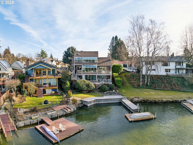 dock area with stairway, a water view, and a residential view