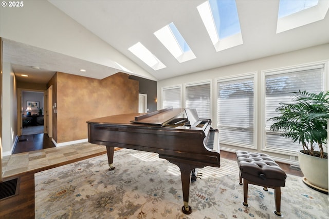 living area with lofted ceiling, baseboards, and visible vents