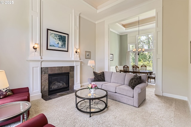 31235 SW Willamette Way, Wilsonville, OR 97070 - carpeted living room with a chandelier, a raised ceiling, baseboards, a fireplace, and crown molding