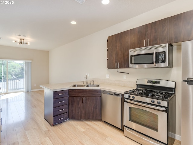 10442 SW Akilean Ter, Portland, OR 97223 - kitchen featuring stainless steel appliances, a sink, a peninsula, light countertops, and dark brown cabinetry