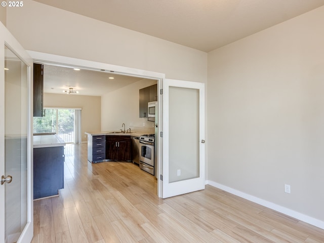 10442 SW Akilean Ter, Portland, OR 97223 - kitchen featuring appliances with stainless steel finishes, light countertops, light wood-style floors, and a sink