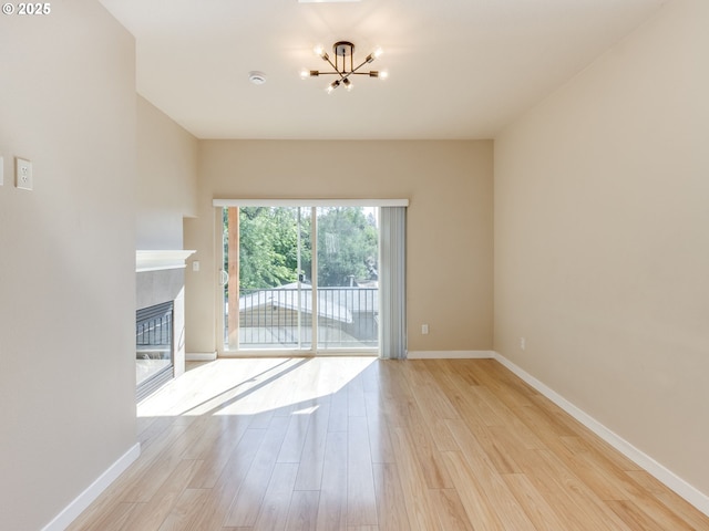 10442 SW Akilean Ter, Portland, OR 97223 - unfurnished living room featuring a chandelier, light wood-style floors, baseboards, and a fireplace