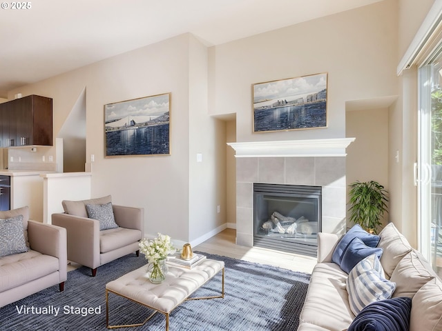 10442 SW Akilean Ter, Portland, OR 97223 - living area featuring a tiled fireplace, wood finished floors, and baseboards