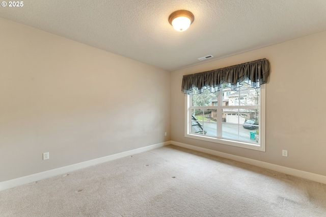 unfurnished room with light carpet and a textured ceiling