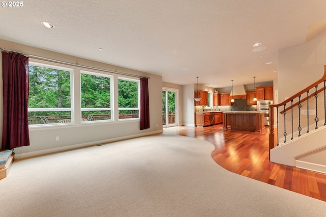 unfurnished living room with hardwood / wood-style floors and a textured ceiling