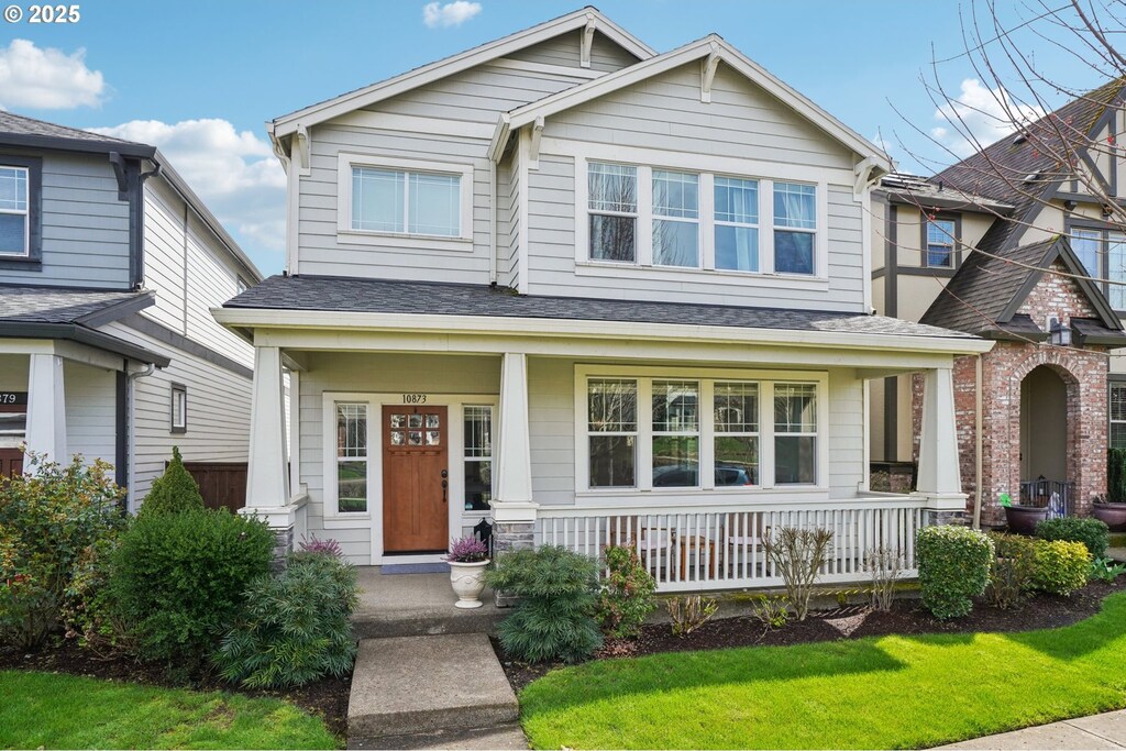 craftsman-style home with roof with shingles and covered porch