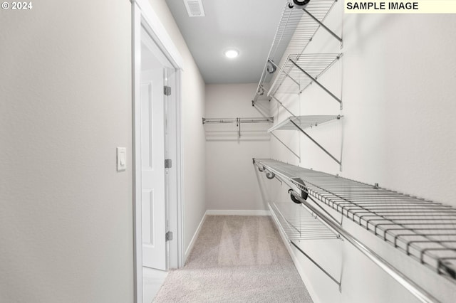 spacious closet with visible vents and light colored carpet