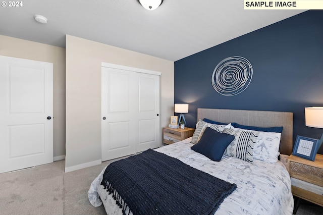 bedroom featuring baseboards, a closet, and light colored carpet