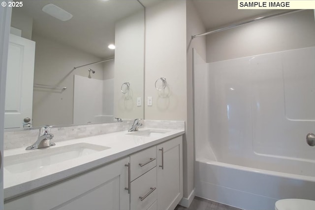 full bathroom featuring double vanity, tub / shower combination, and a sink