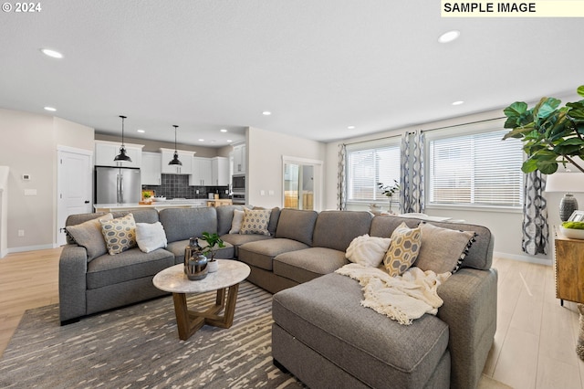 living room featuring recessed lighting, baseboards, and wood finished floors