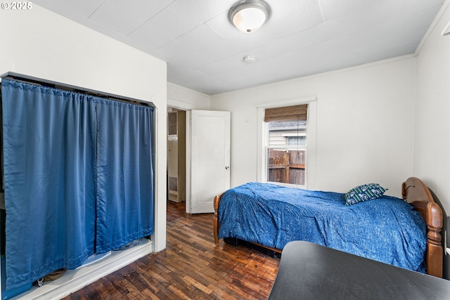 bedroom featuring ornamental molding and wood finished floors