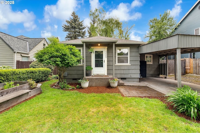 view of front of house with a front lawn, fence, a vegetable garden, an attached carport, and crawl space