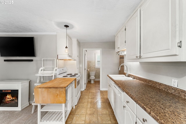 kitchen with white appliances, white cabinetry, extractor fan, and a sink