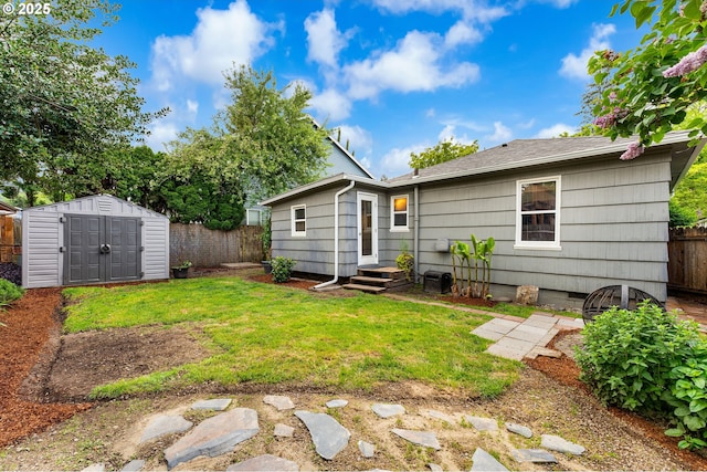 rear view of house with a storage shed, a yard, an outdoor structure, and a fenced backyard