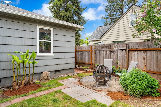 view of yard with fence and an outdoor fire pit