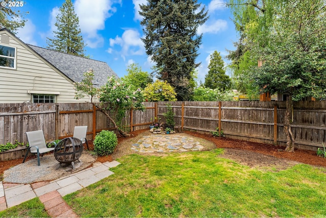 view of yard with a fenced backyard, a patio, and an outdoor fire pit