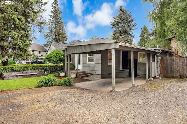 exterior space with fence and roof with shingles