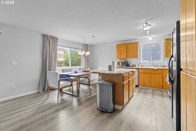 15302 NE 88th St, Vancouver, WA 98682 - kitchen with stainless steel appliances, a center island, light wood-type flooring, light countertops, and a textured ceiling