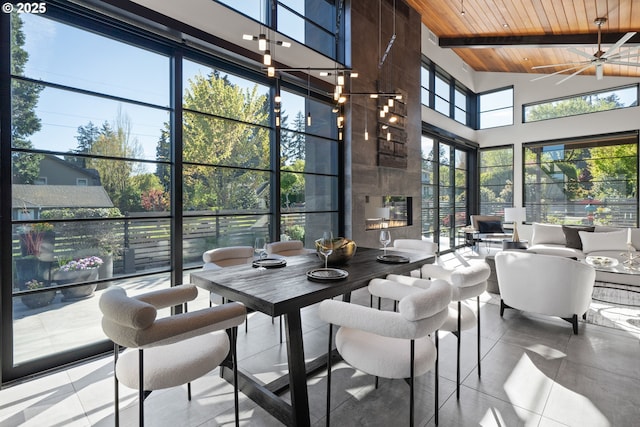 sunroom with wooden ceiling, tile patterned flooring, high vaulted ceiling, and beam ceiling