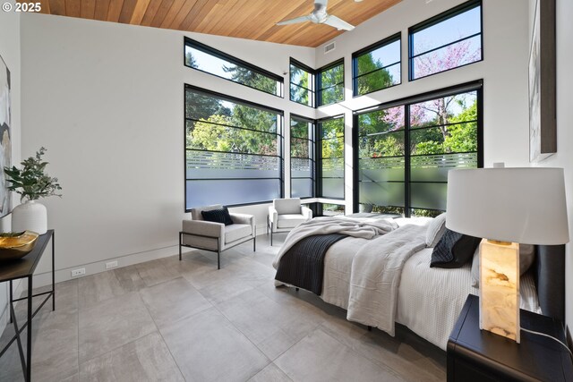 bedroom featuring baseboards, visible vents, wooden ceiling, and a towering ceiling
