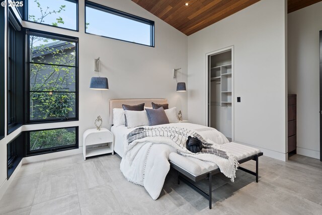bedroom featuring a closet, high vaulted ceiling, multiple windows, and wooden ceiling