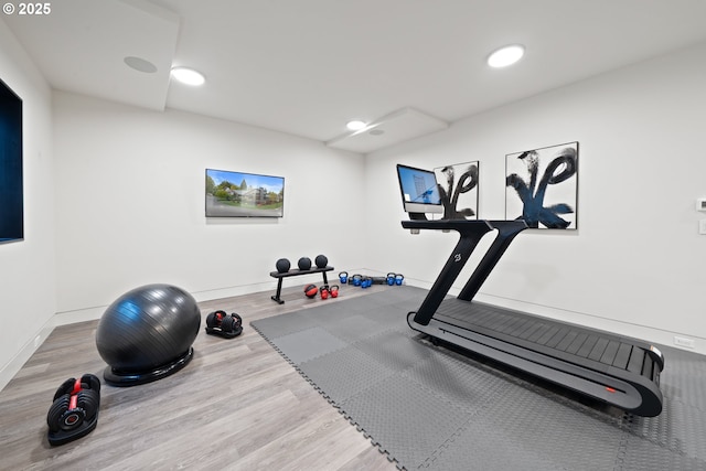 workout area featuring baseboards, recessed lighting, and wood finished floors