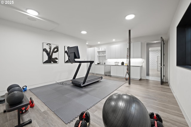 exercise area with light wood-type flooring, recessed lighting, and baseboards